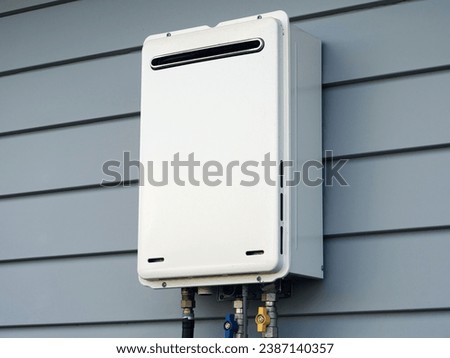 Modern external continuous flow gas water heater mounted on house wall Royalty-Free Stock Photo #2387140357