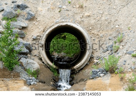 A close up image of a large concrete culvert redirecting waste water run off. Royalty-Free Stock Photo #2387145053