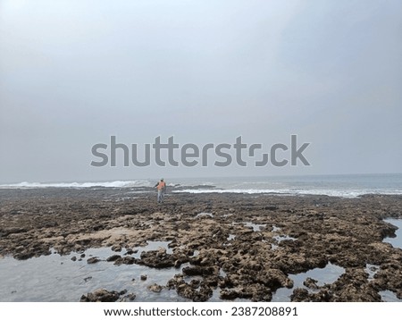 BENGKULU, SUMATRA, INDONESIA - 11-12-2023: PICTURE VIEW WHEN THE TIDES ARE A FISHERMAN FISHING FROM THE PROGRESS