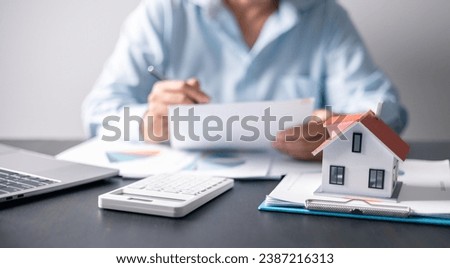 House with money. Concept of finance or refinance real estate. Symbol of house stands against background of us dollars. Property investment. Home mortgage loan rate. Saving money for retirement. Royalty-Free Stock Photo #2387216313