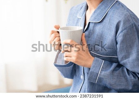 
Lifestyle image of a young woman in pajamas