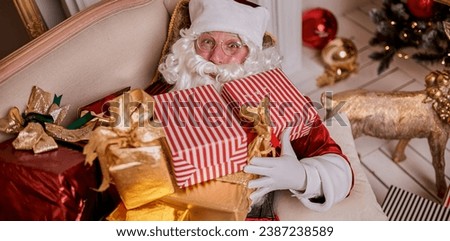 Happy Santa Claus with gifts near fireplace and christmas tree. New year and Merry Christmas concept