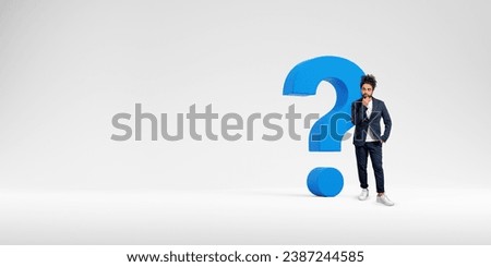 Thoughtful Middle Eastern businessman standing near big blue question mark over white copy space background. Concept of choice and bright idea search