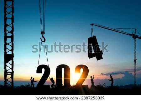 Silhouette of construction worker with crane and cloudy blue sky for preparation of welcome 2024 new year party and change new business. Royalty-Free Stock Photo #2387253039