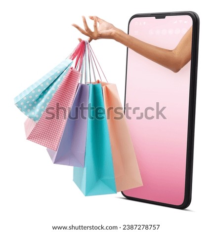 Female hand holding many shopping bag pink and light blue color. Coming out from mobile phone with pink screen. Isolated on white background.