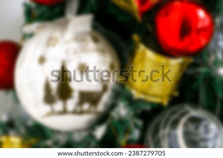 Blurred festive background shot of Christmas tree decorated with ornaments, red baubles, gold wrapped gifts and golden drums