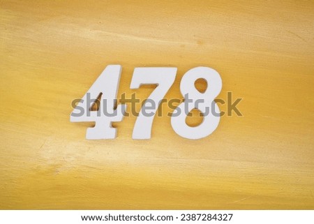 The golden yellow painted wood panel for the background, number 478, is made from white painted wood. Royalty-Free Stock Photo #2387284327
