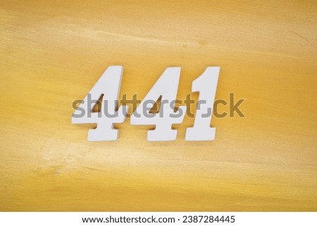 The golden yellow painted wood panel for the background, number 441, is made from white painted wood. Royalty-Free Stock Photo #2387284445