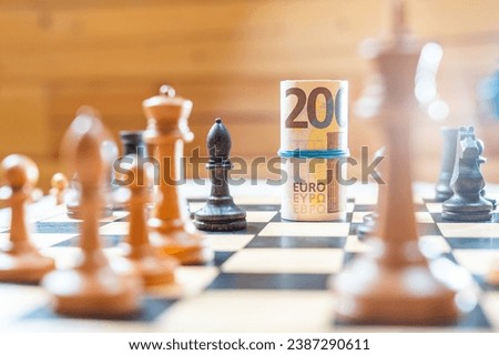 Chess board with blurred black and white chess pieces playing against euro bank notes. High quality photo