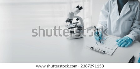 Chemist taking notes on research data, Scientist is working in the laboratory, Chemist is analyzing experimental results and taking notes in the laboratory, lab idea. Royalty-Free Stock Photo #2387291153