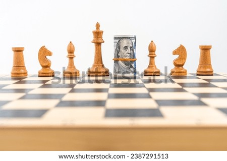 Chess board with one line of white figures, American banknotes rolled and placed instead of white queen. Concept of business strategy, dollar leadership, competition. High quality photo