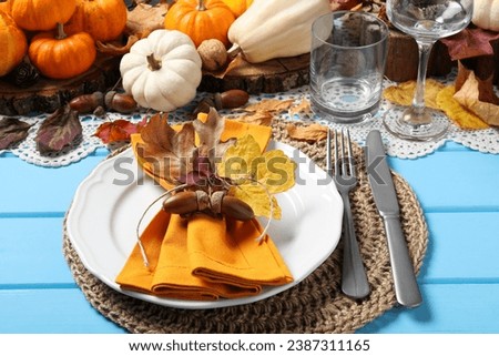 Happy Thanksgiving day. Beautiful table setting with autumn decor on light blue wooden background