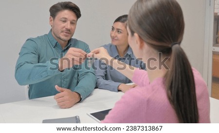 Interracial Couple Shaking Hand with Female Agent after Giving Money
