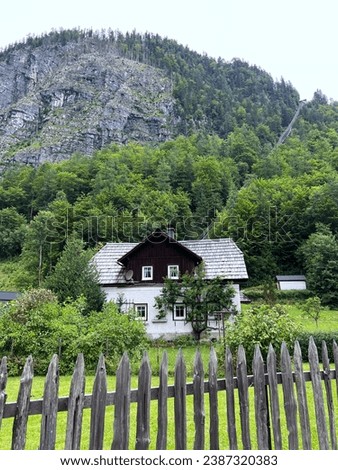 Single house on the outskirts of the city, house on the mountainside with trees, secluded place for house rental in the alps secluded alpine rental, city outskirts house, mountainside living, solitary Royalty-Free Stock Photo #2387320383