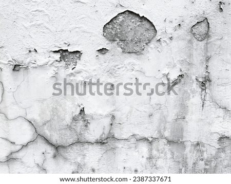 Photo of a damaged destroy and textured wall that has been painted long time ago but the pain is cracking now makingit look dirsty and abandoned