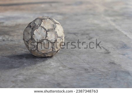 Old, torn, dirty and damaged soccer or football ball