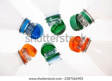 Plastic bottles with tethered caps in different colors Royalty-Free Stock Photo #2387366903