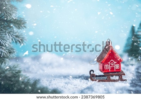 Christmas tree toy in the form of a red house on a sleigh in the snow. christmas, new year background, with copy space, concept House insurance, house gift