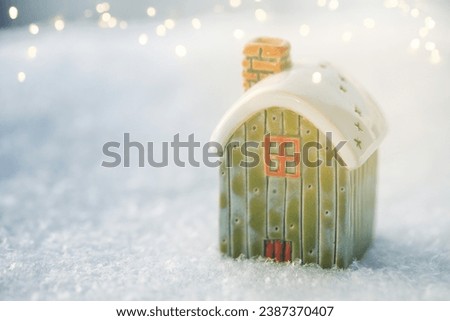Toy house on snow, natural abstract background. Copy space