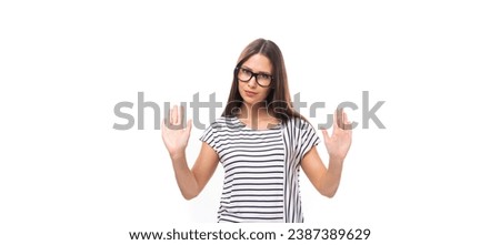 young pretty european brunette woman in a striped sweater gesturing actively on a white background with copy space