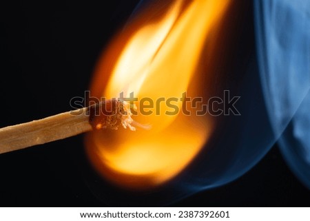 a wooden safety matchstick burning  Royalty-Free Stock Photo #2387392601