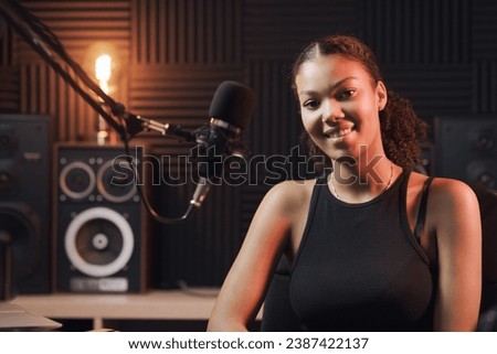 Young artist posing in the recording studio, she is smiling at camera