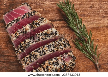 fillet of red tuna meat, fried in sesame seeds, homemade, close-up, no people, on a wooden background, Royalty-Free Stock Photo #2387433013