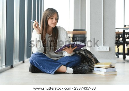 education and school concept - student girl studying and reading book at school