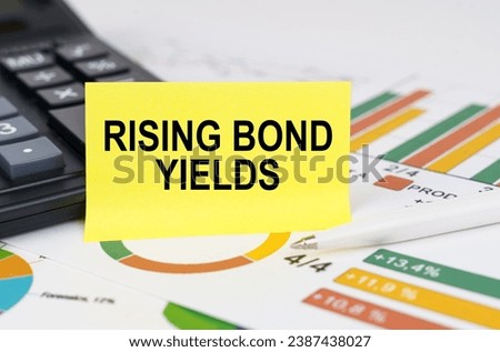 Business concept. On business reports there is a calculator and a sign with the inscription - rising bond yields