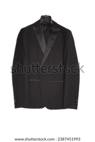  Black men's tuxedo. Jacket and trousers on a hanger, on an isolated background Royalty-Free Stock Photo #2387451993
