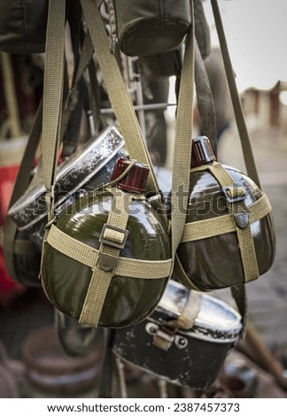 Russian Soviet Red Army Soldier's Military Equipment Of World War II. Flasks And Holster Hanging. A soldier's water flask. Soldier's uniform. An army soldier's water canister. Royalty-Free Stock Photo #2387457373