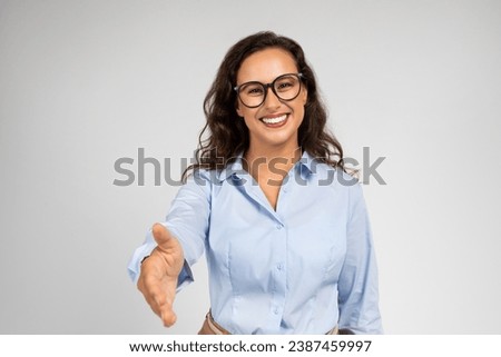 Smiling pretty young caucasian woman manager in formal, glasses make shake hands for say hello, isolated on gray background studio background. Professional work, business, greeting, introduction