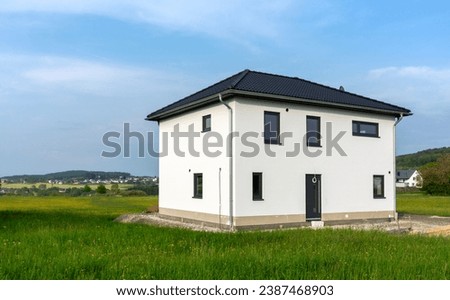 Almost finished prefabricated house in green nature in German rural region Royalty-Free Stock Photo #2387468903