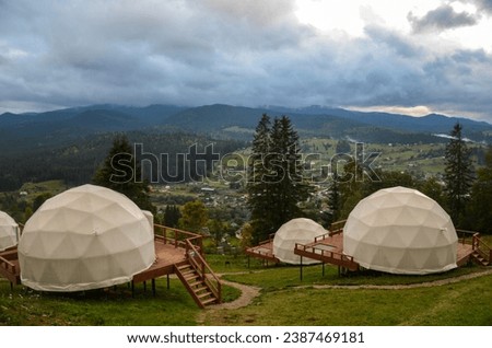 Glamping (glamour camping) is a domed eco-hotel with an incredible view of the surrounding natural panoramas of forested mountains. Glamping is where stunning nature meets modern luxury Royalty-Free Stock Photo #2387469181