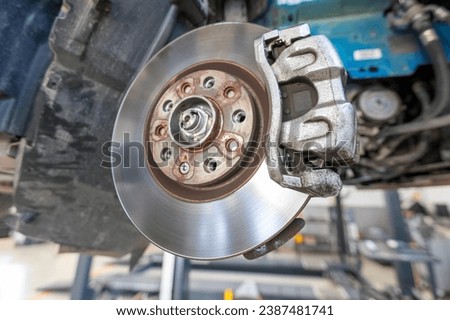 View of brake pads, wheel hub, rotor (disk) and caliper in car. Brake pads are a component of disc brakes used in automotive and other applications. Brake pads are composed of steel backing plates.