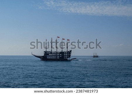 Large black tall ship on the high seas at dusk
