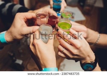Close up shot of group of people clinking glasses with wine or champagne in front of bokeh background older people hands