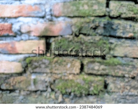 blurred photo of a wall made of red and gray brick and cement