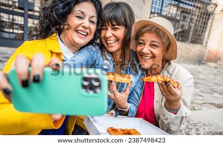 Three senior women eating pizza slice sitting outside - Happy female friends  taking selfie picture with smart mobile phone  - Lifestyle concept with mature people having fun together hanging outdoors