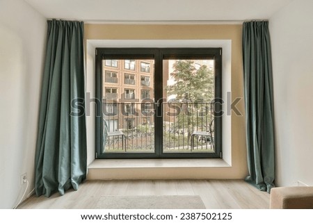 a living room with an open window and sliding glass door that opens to the patio area, which has been used for several years Royalty-Free Stock Photo #2387502125