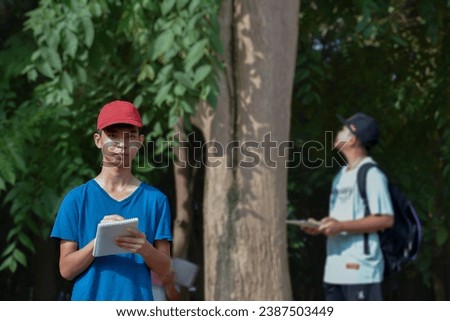 Group of asian schoolboy spending their free times afterschool by learning species of plants, insects, animals and trees at school botanical garden, new edited.