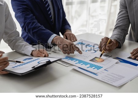 Team of business people working with Paperwork on a table in a conference room in a business presentation or seminar. The document contained financial or marketing figures, graphs, and charts with a l