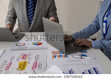 Team of business people working with Paperwork on a table in a conference room in a business presentation or seminar. The document contained financial or marketing figures, graphs, and charts with a l