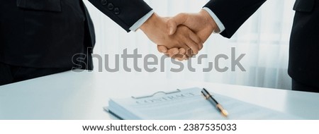Two business executive shake hand in boardroom, sealing agreement merging two company. Handshake symbolize business partnership and cooperation. Corporate acquisition and merger concept. Shrewd Royalty-Free Stock Photo #2387535033
