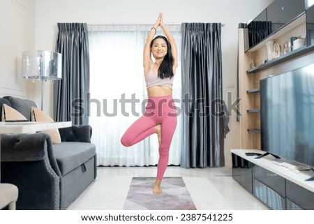 Calm of wellness Asian young woman sit on yoga mat,Yoga meditation of young healthy woman relax and comfortable at white cozy home,Yoga Exercise for Wellness Concept.