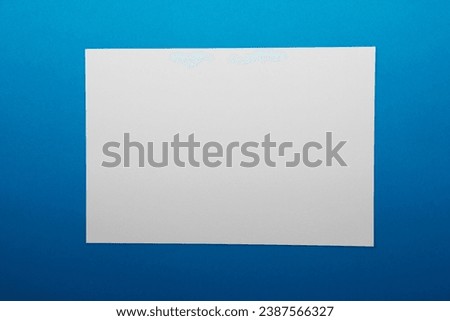 Blank white business card on blue background. Copy space for text.