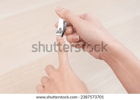 Nail good hygiene, young woman hand manicure with nail clipper cutting fingernail on long or dirty finger, using nail sharp clipper make with stainless steel. Healthy care clean body by cut short trim Royalty-Free Stock Photo #2387573701