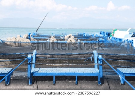 several series of floating net cages on the coast of a beach for sustainable fish farming