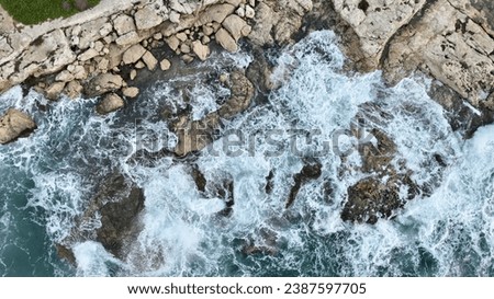 Aerial view of sea waves hitting the rocks with drone