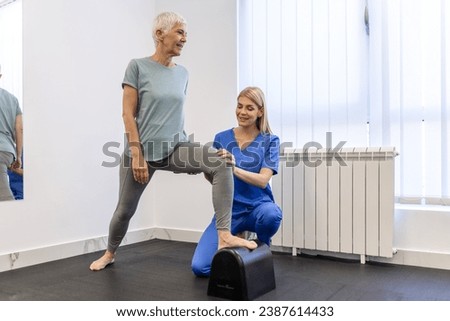 Senior patient at the physiotherapy doing physical exercises with her therapist, doing leg physiotherapy for elderly woman, to treat osteoarthritis and nerve pain in the leg.